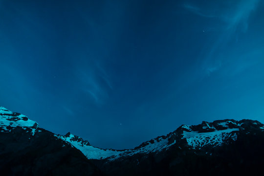 A Starry Night With Wispy Clouds High In The Snowy Mountains