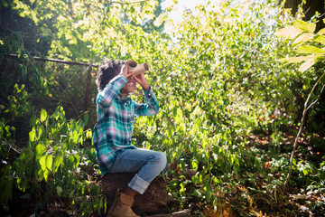 Girl exploring backyard with pretend binoculars