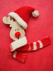Cute wooden deer in red hat of Santa Claus. Funny Christmas background