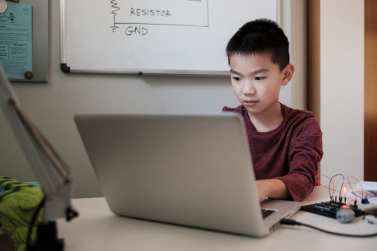 Boy working on an electronic DIY kit at home