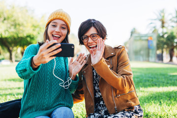Mother and her daughter making a video call on the street.