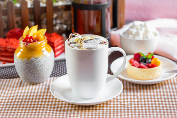 cup of coffee with marshmallow and topping with nuts