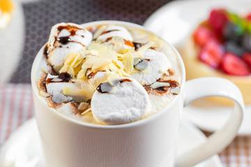 cup of coffee with marshmallow and topping with nuts