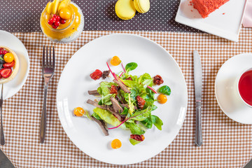 Salad with meat, arugula, algae, tomatoes and greens