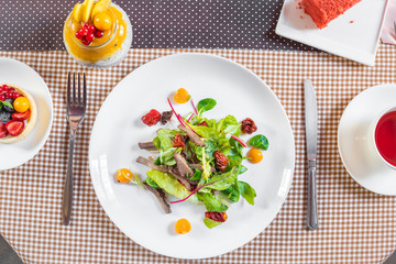 Salad with meat, arugula, algae, tomatoes and greens