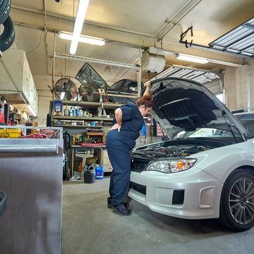 Female Mechanic Working on Cars in Her Shop