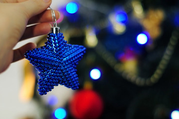 Рождественские игрушки в руках у девушки. Девушка украшает елку. С новым годом! Счастливого Рождества! 