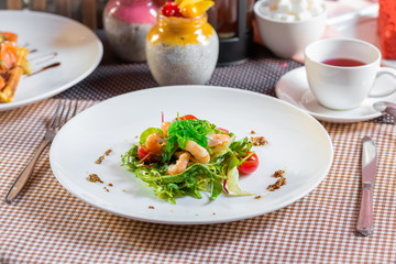 Salad with shrimps, arugula, algae, tomatoes and greens