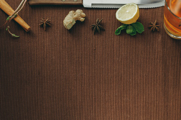 Oriental tea on a brown cloth Mat with spices and lemon. Lemon, mint, ginger, cinnamon. Copy space
