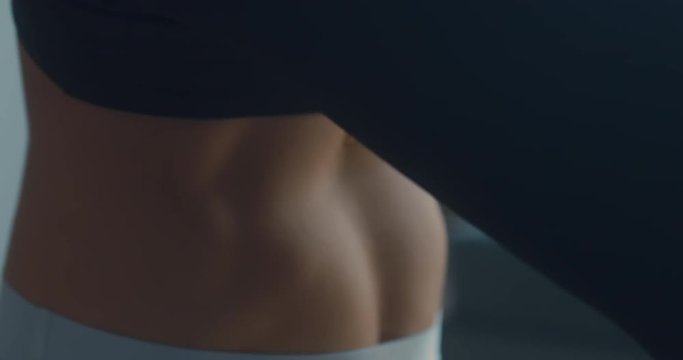 EXTREME CU view of slim female belly while practicing yoga. 4K UHD
