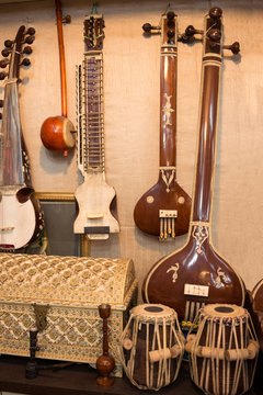 Indian musical instruments stringed guitars called sitars and Indian Folk percussion barrel shaped bass drums to produce classical music
