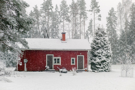 Small red cabin in heavy snowfall - Powered by Adobe