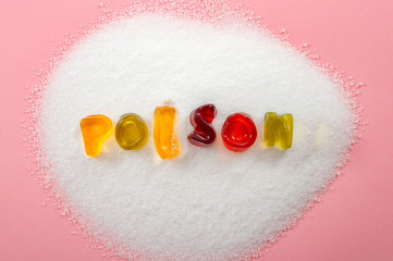 Sugar is toxic, unhealthy diet and refined sugars concept with close up on the word poison written into a pile of white granulated sugar with gummy letters