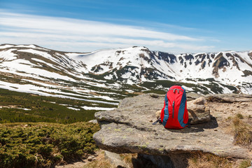 A backpack on a stone at the mountains background. The concept of travels