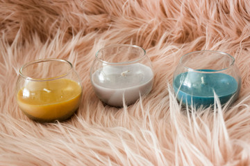 set detail of decoration with three candles of yellow gray and blue colors on pink background