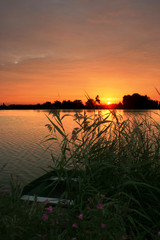 Rowing boat at the shore of lake 'Rottemeren', Holland at sunset.