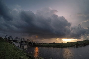 Obraz premium Bridge with stormcloud at sunset
