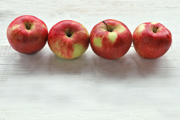 Red apples on white wooden background 