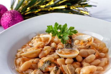 A plate of white beans with clams and prawns and Christmas decoration