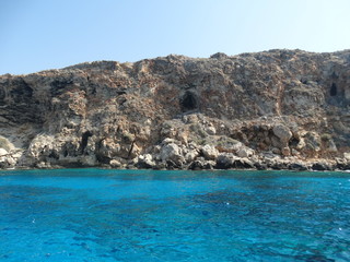 the rocky shores of Cyprus on the Mediterranean Sea in the summer during a family holiday and sailing on a yacht in 2018