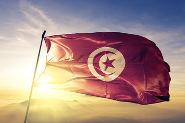 Tunisia tunisian flag textile cloth fabric waving on the top sunrise mist fog