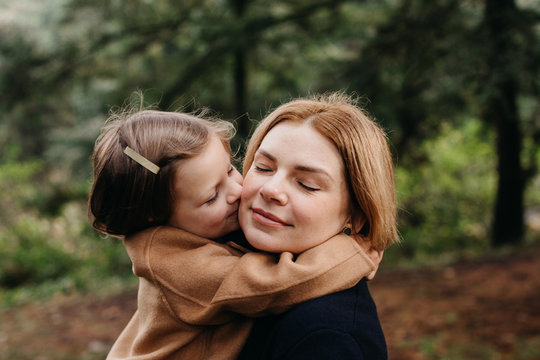 Daughter kissing her mother outdoors
