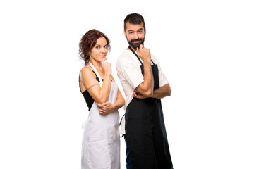 Couple of cooks smiling and looking to the front with confident  on isolated white background