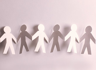 group of paper men holding each other's hands
