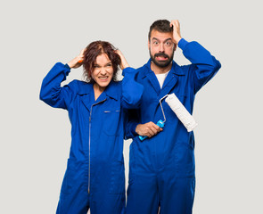 Painters takes hands on head because has migraine on isolated grey background