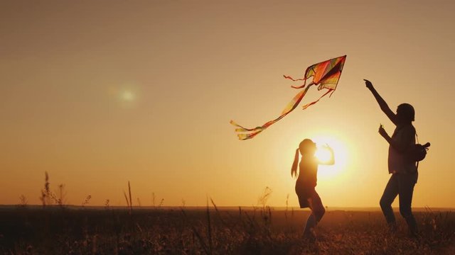 Mom plays with her daughter. Carelessly launch a kite. Happy life, summer activity concept