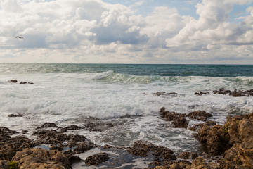 Fototapeta na wymiar the stone Beach ocean wave sky with clouds