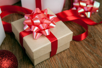 One festive gift box with a red bow on a wooden table