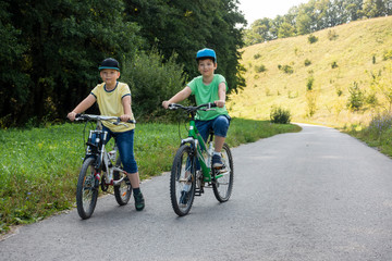 Fototapeta na wymiar two brothers ride bikes summer outdoors.