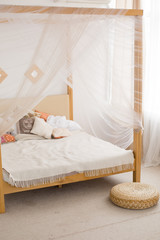 wooden double bed in a large white room. bright room with large Windows. interior, bright rooms