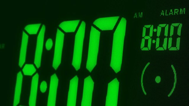 Digital alarm clock waking up at 8 AM. Close-up LED display. The numbers on the clock screen changes from 7:59 no 8:00 AM. Then alarm logo appears on the screen. 3D rendering animation.
