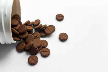 Few brown detox pills on white background