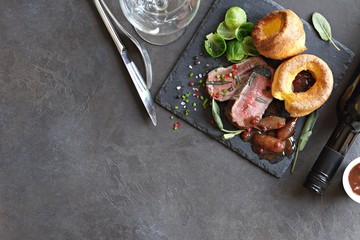 
    Roast beef with yorkshire pudding, brussels sprouts and shallots. Traditional british roast beef. Overhead view