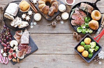 Christmas dinner table with roast beef,yorkshire pudding,appetizers platter and traditional cake. Christmass celebration, festive family dinner.  Overhead view.