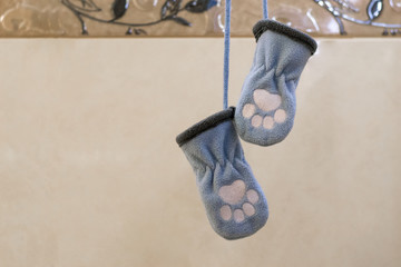 Two blue gloves for newborns with foot marks.