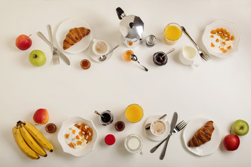 Breakfast time. Croissants and orange juice, jam and honey. Coffee with cream or milk. Fruits - bananas, red and green apples. Ricotta with sour cream, nuts and dried apricots. 