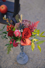 set of autumn wedding decor outdoors. Floral arrangement of flowers and fruits details of the...