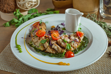 meat ragout with tomatoes in a white dish on a wooden table