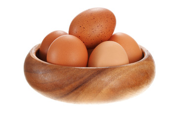 Eggs in a wooden bowl. Isolated on white background.