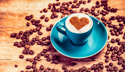 Cup of coffee and beans around. Coffee with heart shape symbol