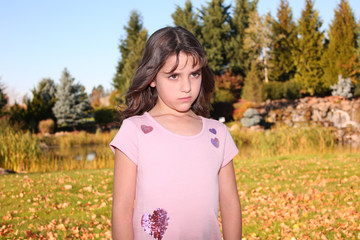 Portrait of Pretty Sad, angry Girl 7-8 years old, with Brown Hair and Big Brown Eyes, in a Pink Sweater, Dress in the Golden Autumn, Portland Oregon