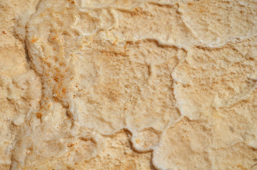 The texture of the dried salt mixed with orange sand. The bottom of the Dead Sea in Israel, the sea dries up and disappears.