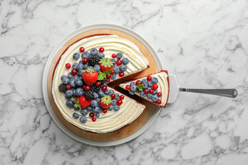 Delicious homemade red velvet cake with fresh berries on marble table, top view