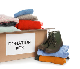 Donation box, shoes and clothes on white background
