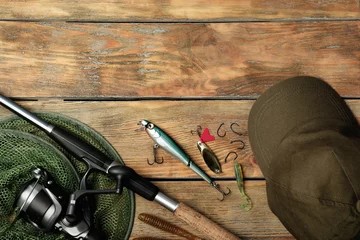 Poster Flat lay composition with fishing equipment and space for text on wooden background © New Africa