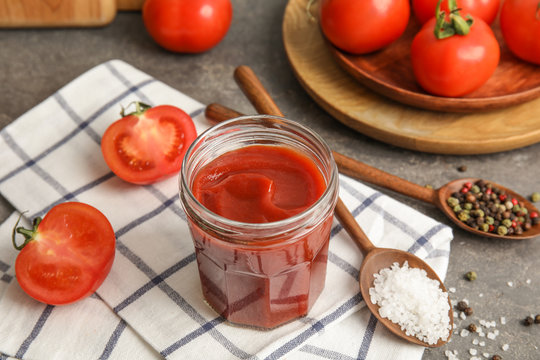 Composition with tomato sauce in jar on table